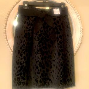 Never worn black skirt with beautiful textured material. Has large bow in front.